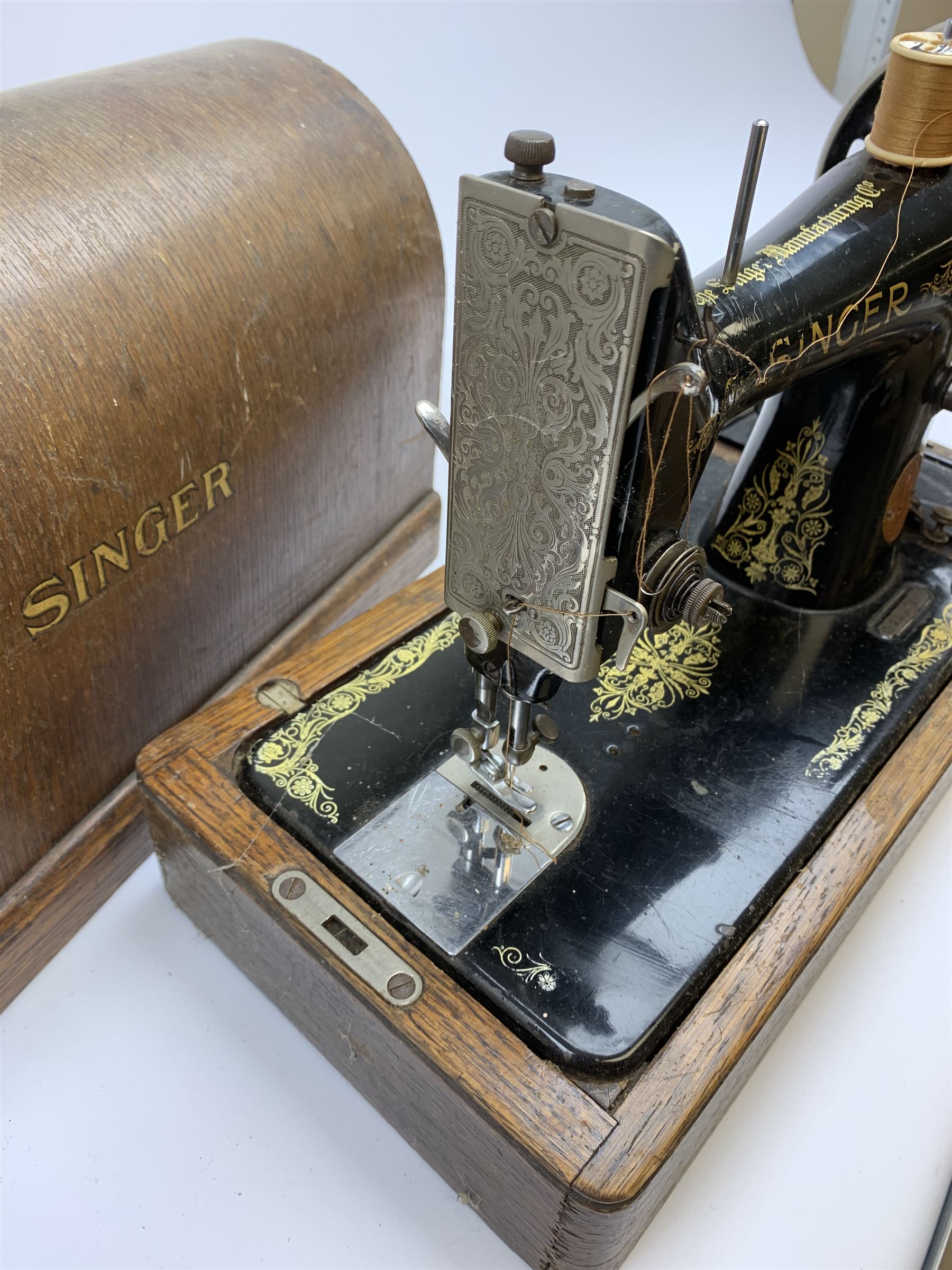 A cased vintage Singer hand crank sewing machine. 