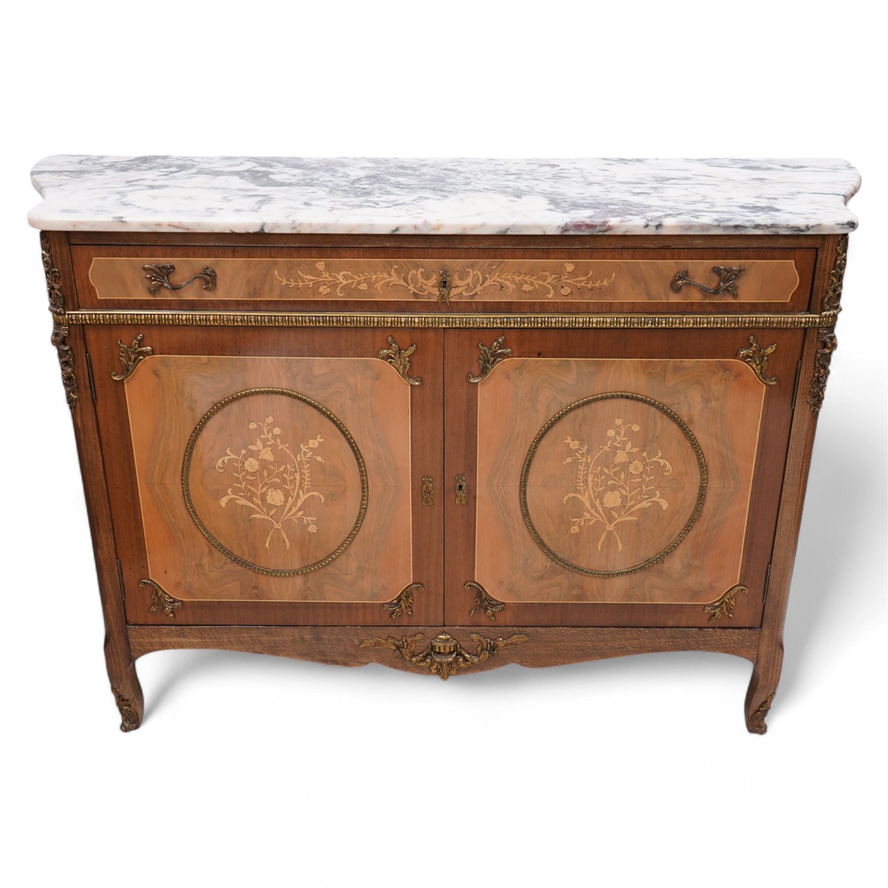 Mid-to-late 20th century mahogany and walnut side cabinet, shaped white and grey variegated marble top, single frieze drawer inlaid with scrolling leafy branches and flower heads, single internal shelf enclosed by two doors inlaid with flowers, decorated with cast gilt metal mounts, on cabriole feet 