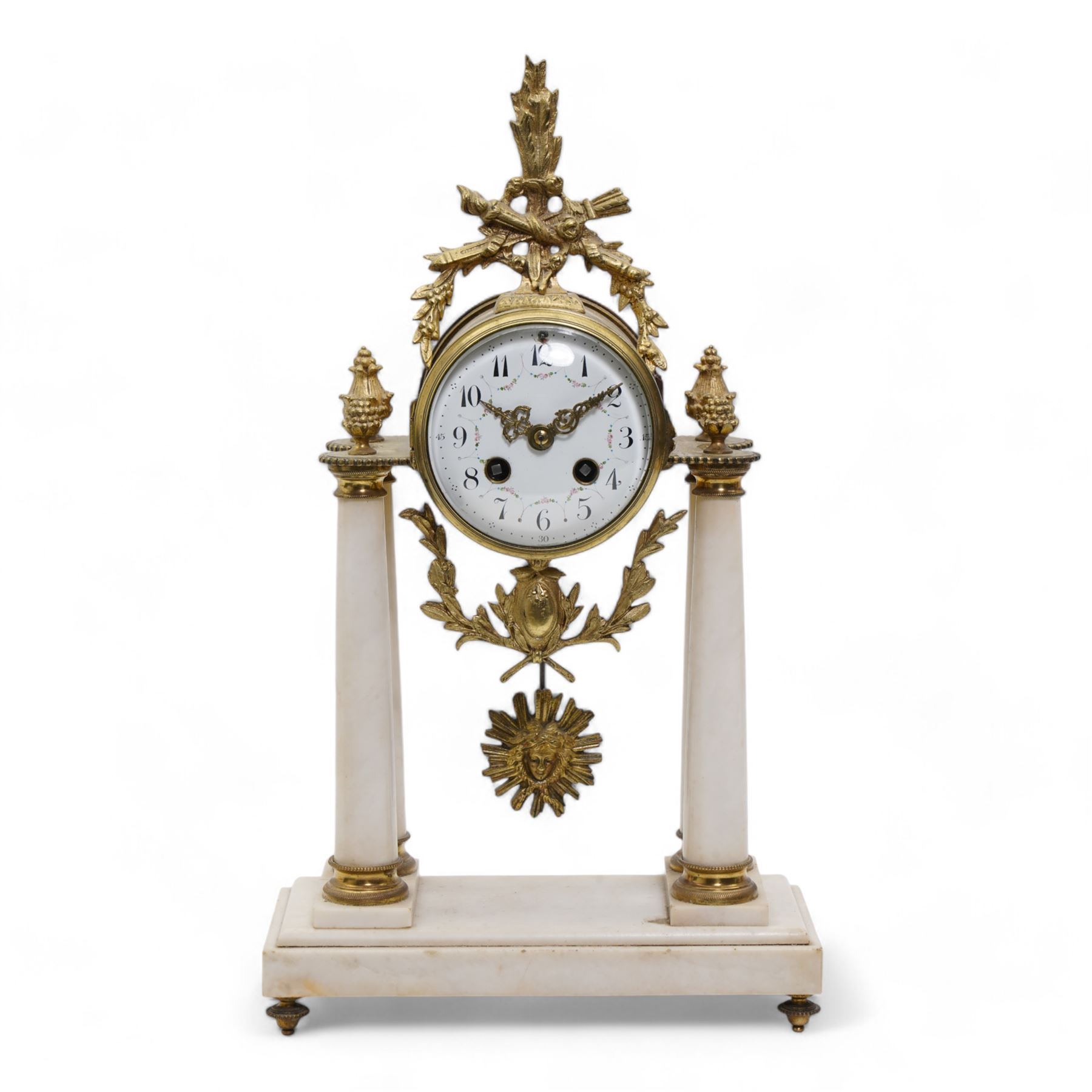 French - White marble and gilt 8-day mantel clock c1900,  with a rectangular plinth raised on four feet, gilt drum movement supported on four tapered pillars with gilt torus base and pineapple finials, convex enamel dial with floral swags and Arabic numerals, minute markers and gilt Louis XV hands, twin train Parisian countwheel striking movement, striking the hours and half-hours on a bell. With a sunburst pendulum.