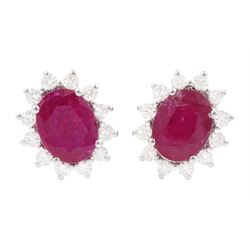 Pair of 18ct white gold oval cut ruby and round brilliant cut diamond stud earrings, stamp...