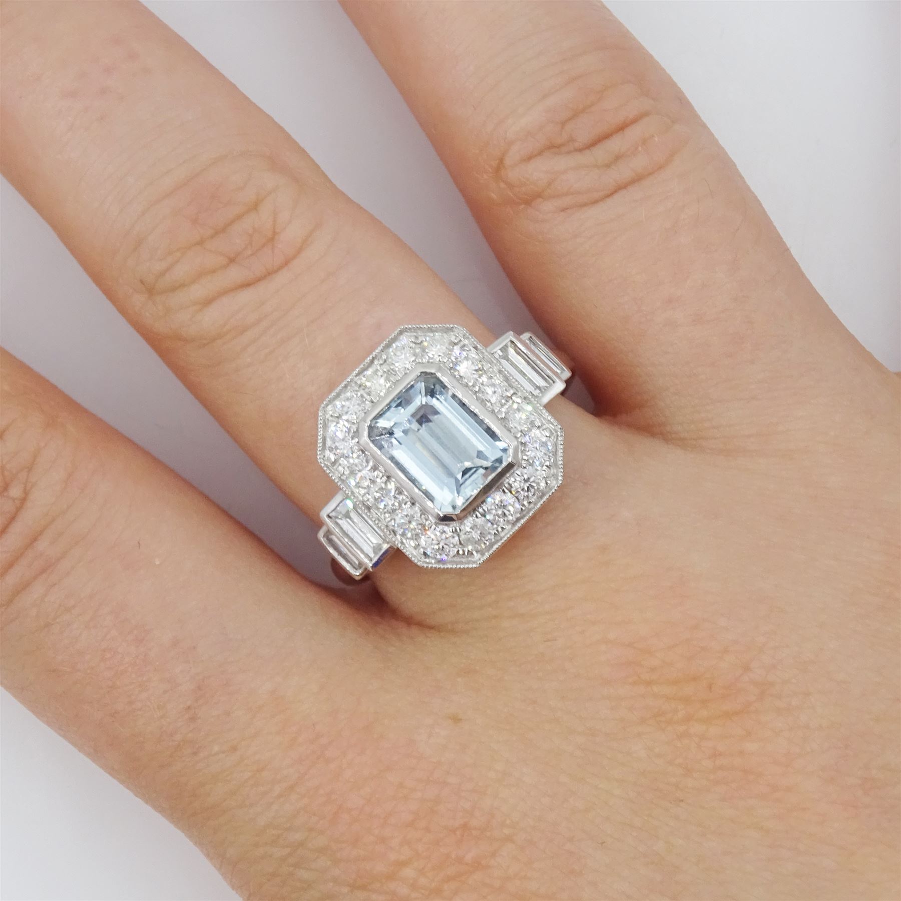 Platinum aquamarine and diamond cluster ring, emerald cut aquamarine of approx 1.40 carat, with milgrain set round brilliant cut diamond surround, each side set with two baguette cut diamonds, hallmarked, total diamond weight approx 1.10 carat