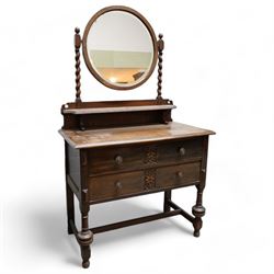 Art Nouveau oak dressing table, raised circular bevelled mirror on spiral turned supports, fitted with two drawers with scrolling foliate carvings, on turned supports joined by stretchers