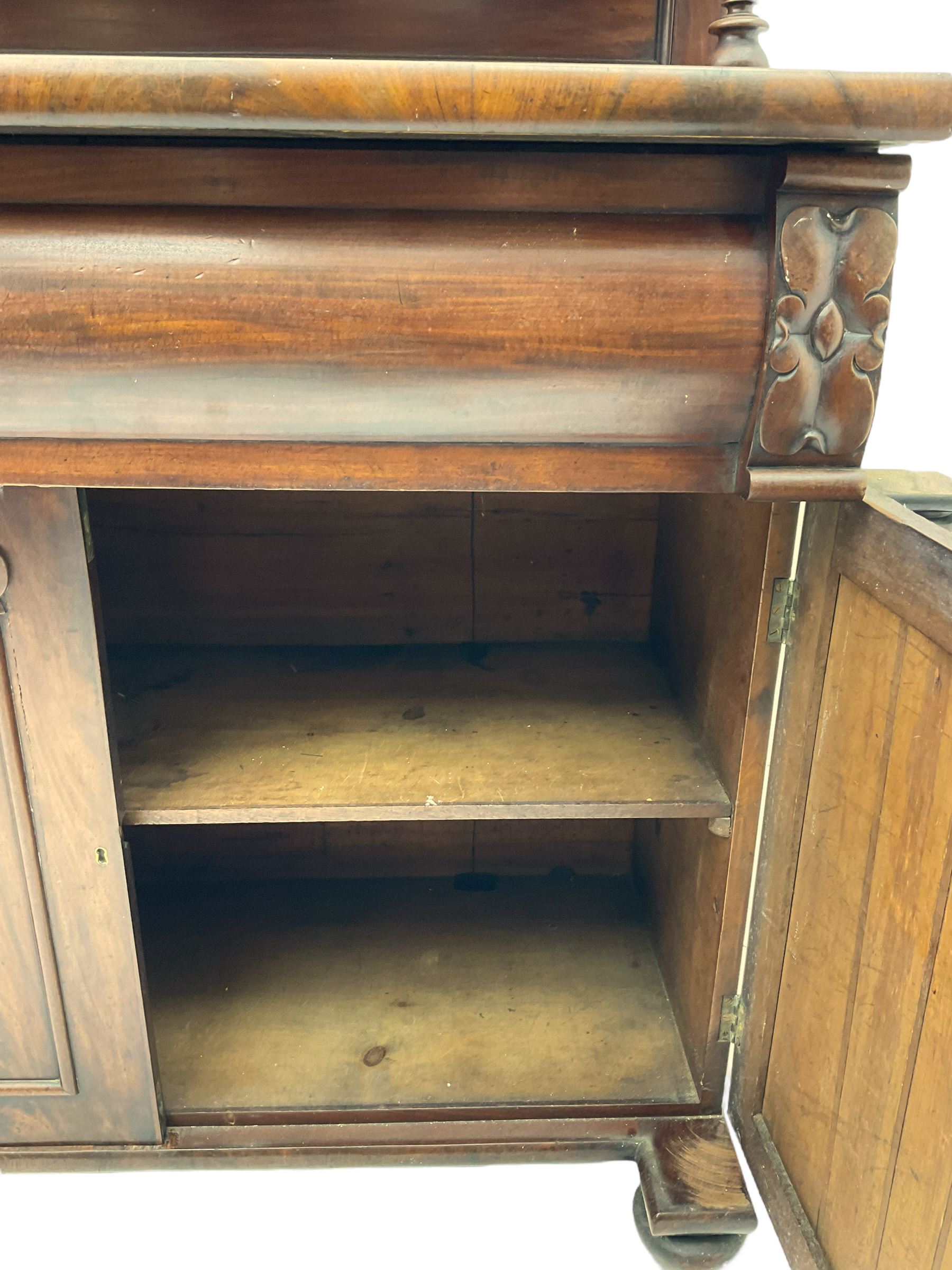 Victorian mahogany chiffonier, raised shaped pediment carved with scrolled extending foliage, two graduating shelves on turned supports, rectangular top over drawer and double cupboard, turned column pilasters, on turned feet 