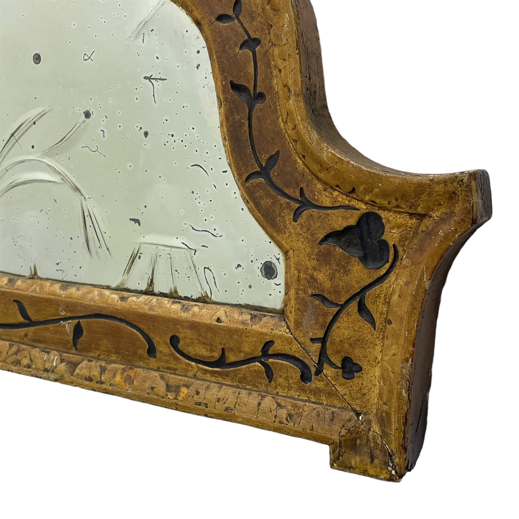 19th century painted pine and gesso wall mirror, stepped arch frame enclosing mirror plate with bevelled stylised leaf decoration and bevelled edge, the frame carved with scrolling leafy branches and painted with black detail, foliate moulded outer edge