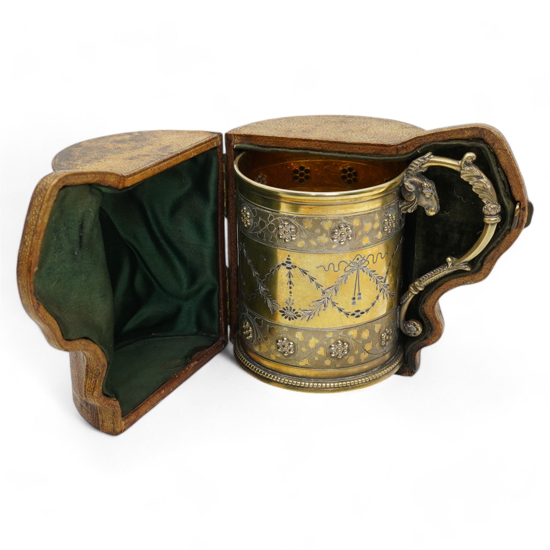 Victorian silver gilt christening mug of Gothic design engraved with trailing garlands with raised beaded flower heads and rams head handle H9cm London 1868 Maker Henry Holland in leather case