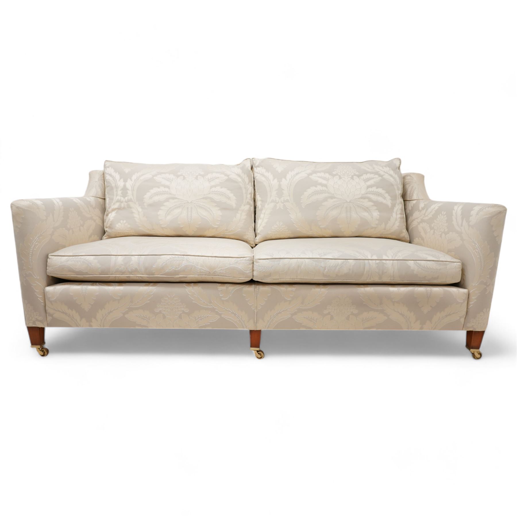 Duresta - Grande hardwood-framed three-seat sofa, upholstered in pale fabric decorated with repeating foliate pattern, on square tapering supports with brass castors 