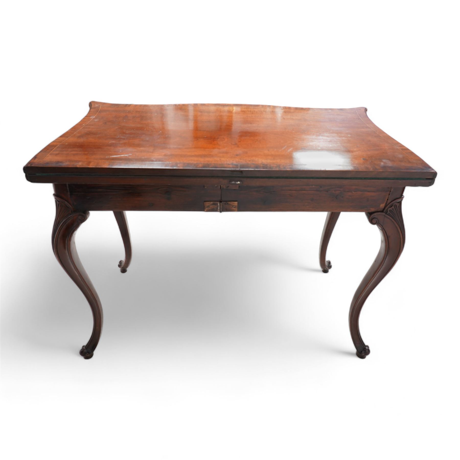 George III inlaid mahogany card table of serpentine form, the shaped rectangular fold-over top decorated with cross-banding and chequered inlay, opening to reveal a baize lined interior, the shaped apron over moulded cabriole supports with scroll and scallop carved knees, on scroll feet