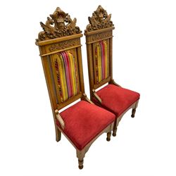 Set of six 20th century Carolean design oak high back chairs, the pediment carved with dragons and central Green Man mask with trailing foliage, the backs upholstered in striped fabric, on turned front supports