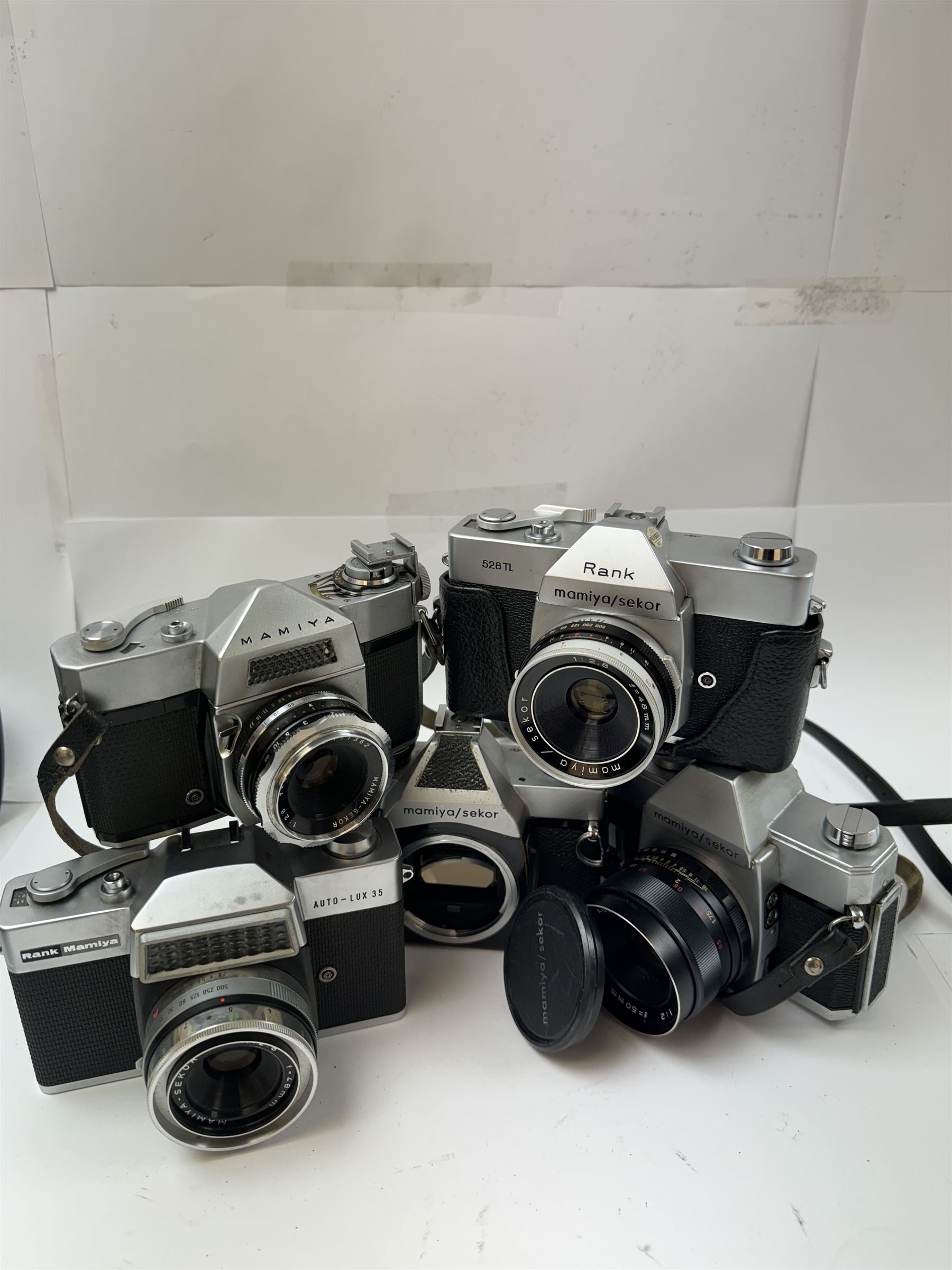 Five Mamiya/Sekor SLR camera bodies, to include autoXTL serial no. PI34456, with a ES 1:18 f=55mm serial no. 28148, Rank 528TL camera body serial no. 18151, with a 1:2.8 f=48mm lens, Rank Mamiya Auto-Lux 35 camera body serial no. 644713, with a 1:2.8 f=48mm lens, 500DTL serial no. 386357, with an Auto 1:2 f=50mm lens serial no. 187863, and one other 