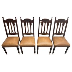 Set of four Edwardian walnut dining chairs, foliate carved high back over sprung seat upholstered in tan faux leather, raised on turned supports