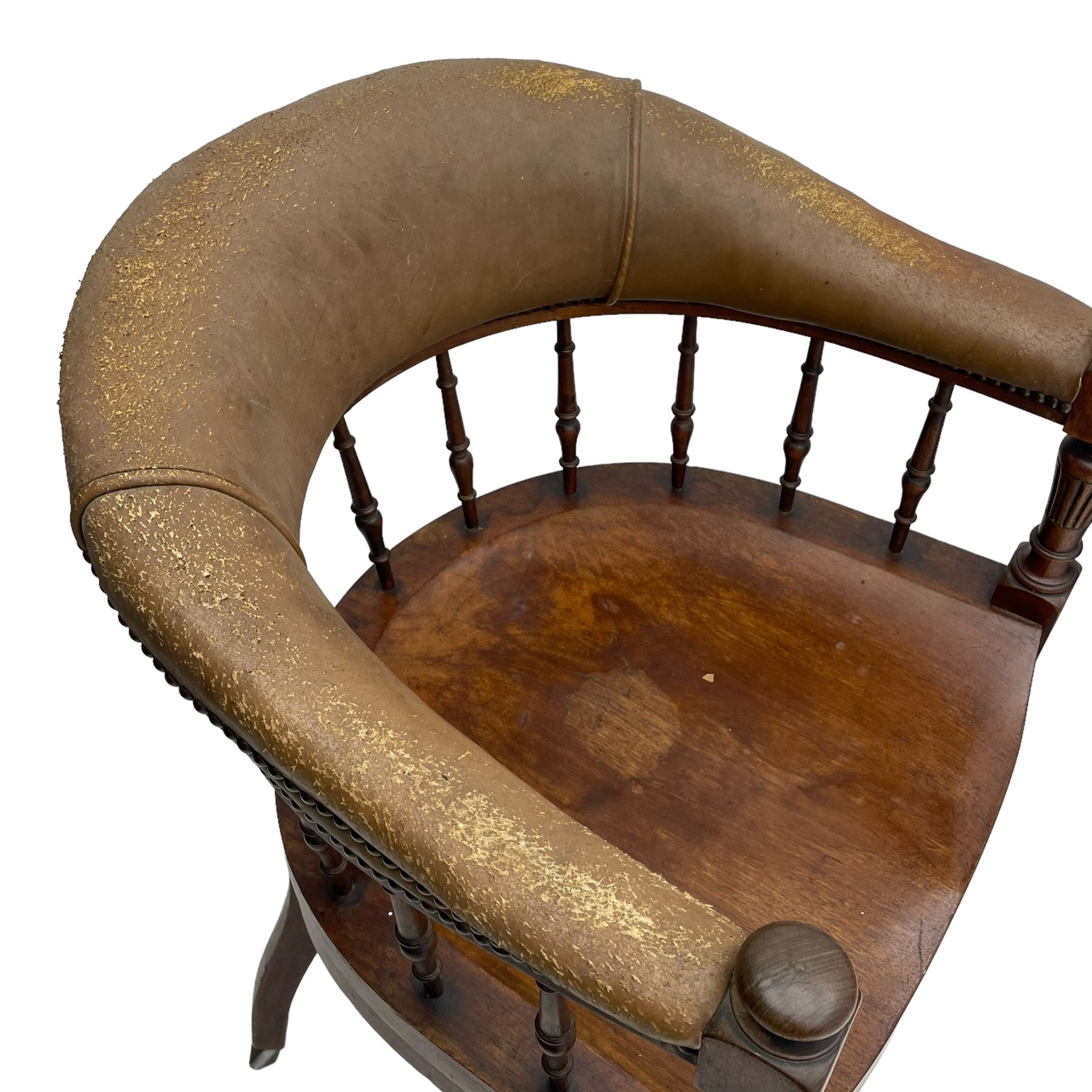 Pair of late Victorian walnut tub-shaped elbow chairs, the cushioned cresting rail upholstered in leather on spindle turned supports, dished saddle seat on turned supports