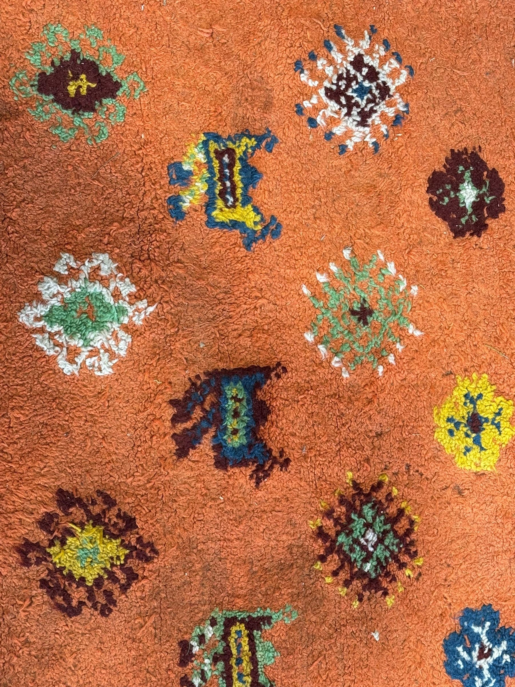 Moroccan amber ground thick pile rug, the field decorated with stylised geometric lozenges and camel motifs, the guard bands with stylised foliate and plant motifs