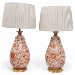 Pair of Chinese porcelain table lamps, of ovoid form, decorated in orange stylised foliage...