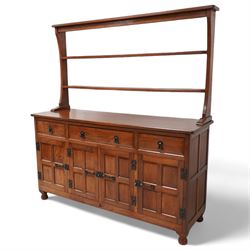 Acornman - oak dresser, raised two heights plate rack over three drawers and panelled cupboards, fitted with wrought metal fittings and handles, carved with acorn signature, by Alan Grainger, Brandsby, York 