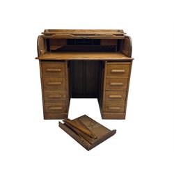 Early 20th century oak twin pedestal desk, tambour roll top enclosing fitted interior, eight drawers, on plinth base