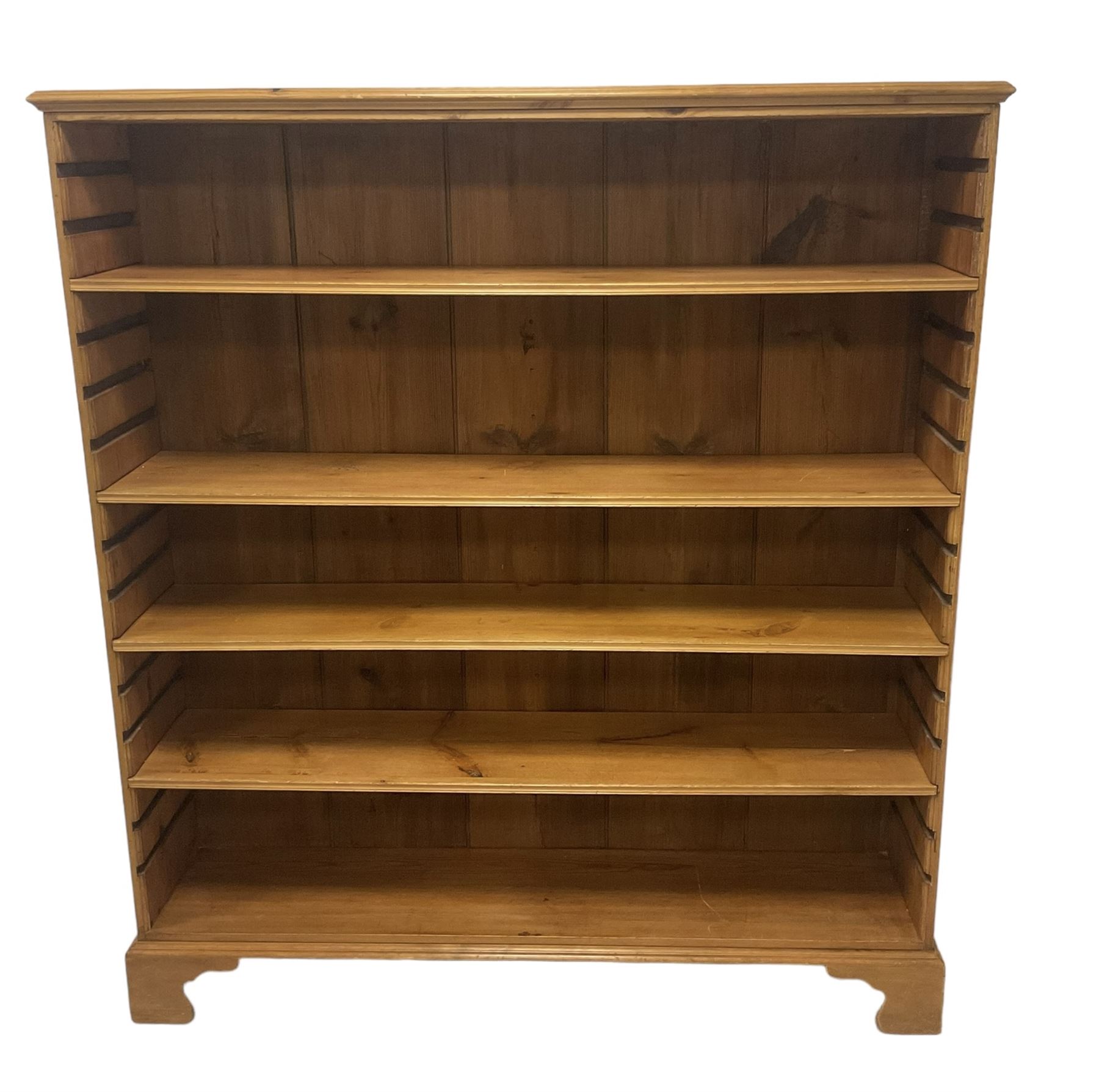 Georgian and later pine open bookcase, fitted with three adjustable shelves, on bracket feet