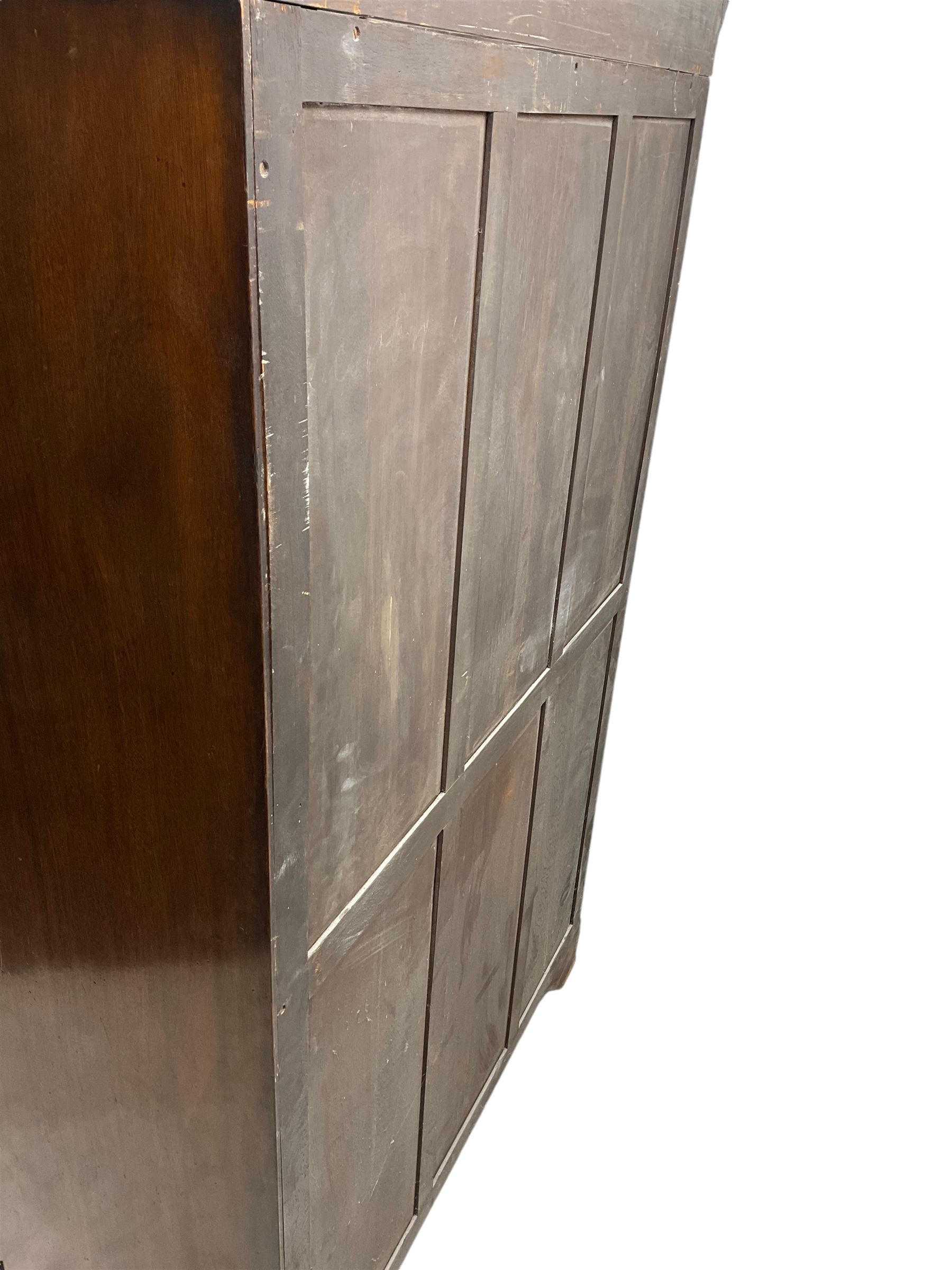 Early 20th century mahogany serpentine double wardrobe, moulded cornice over two figured doors, the interior fitted with hanging rail and shelf, canted and fluted uprights, on bracket feet 