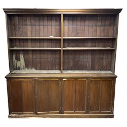 Large 20th century beech bookcase on cupboard, projecting cornice over shelves, the lower section enclosed by two double panelled cupboards, on plinth base