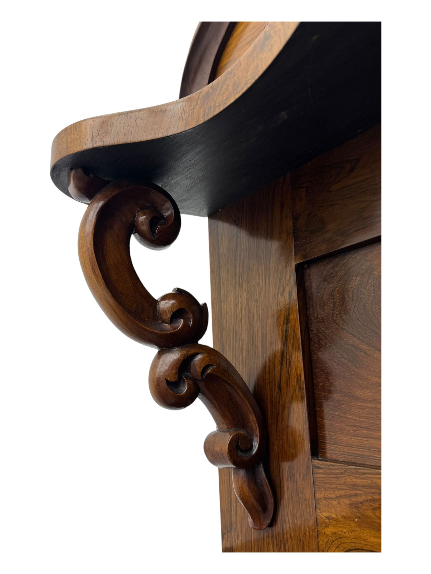 Mid-19th century rosewood chiffonier, raised back with scroll and leaf carved shaped pediment, serpentine top over drawer and double cupboard with scrollwork decoration, on shaped plinth base