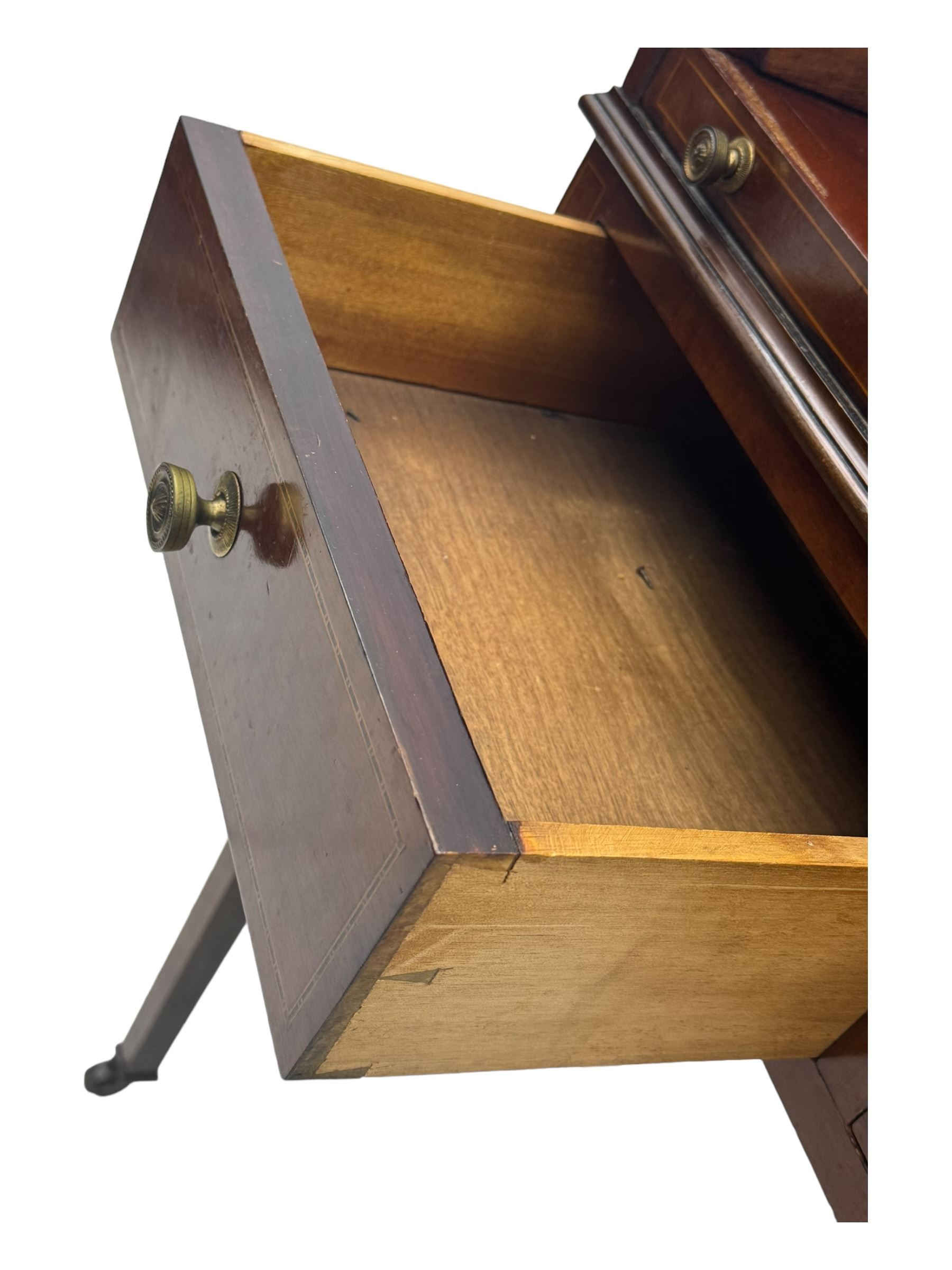 Edwardian inlaid mahogany roll-top desk, cylindrical lid enclosing fitted interior with pigeonholes, drawers and retractable writing surface, over two drawers with brass pull handles, on tapered supports with brass and ceramic castors