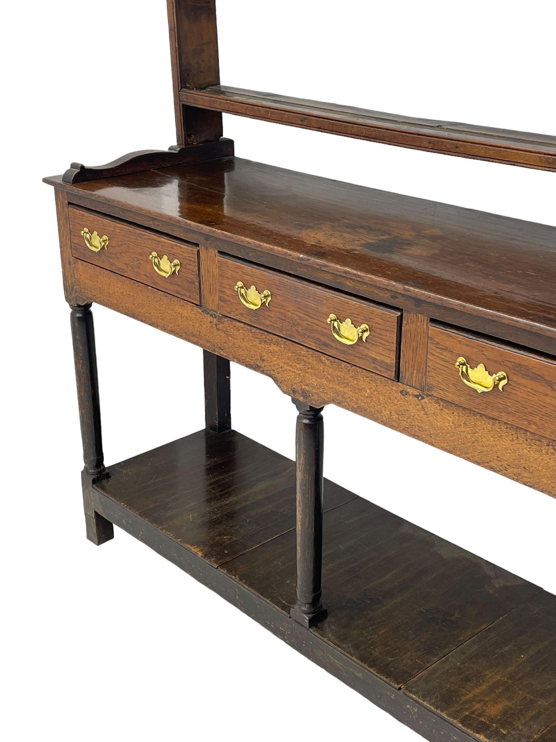 18th century oak dresser, raised three tier plate rack with moulded cresting rail, rectangular top over three drawers, the drawer fronts with moulded edges, turned supports united by pot board base 