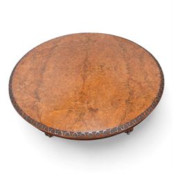 Victorian figured walnut breakfast or centre table, circular tilt-top with carved edge and quarter-matched veneers, turned pedestal with foliate carved baluster on three out splayed supports decorated with floral carvings and scrolled terminals, on brass castors 