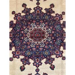 North East Persian Meshed carpet, the field with large central medallion decorated with stylised plant motifs, the field surrounded by panels, medallions and spandrels decorated with floral motifs, indigo ground border with overall floral design 