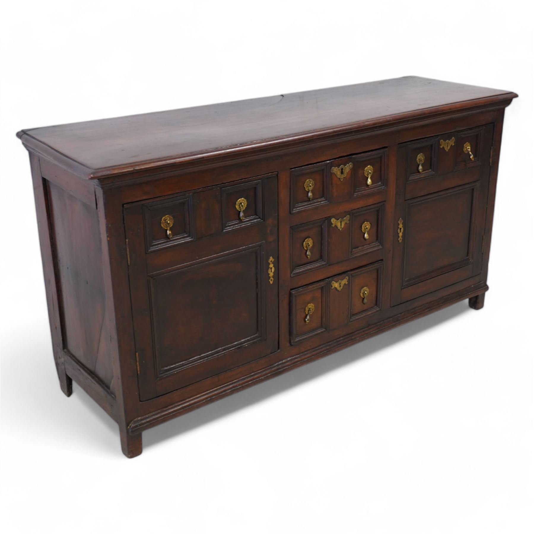 George III elm dresser base, the rectangular top with moulded edge, fitted with three central graduating twin-panelled drawers, flanked by two cupboard doors moulded with false drawer facias over large panels, lower moulded edge over stile feet