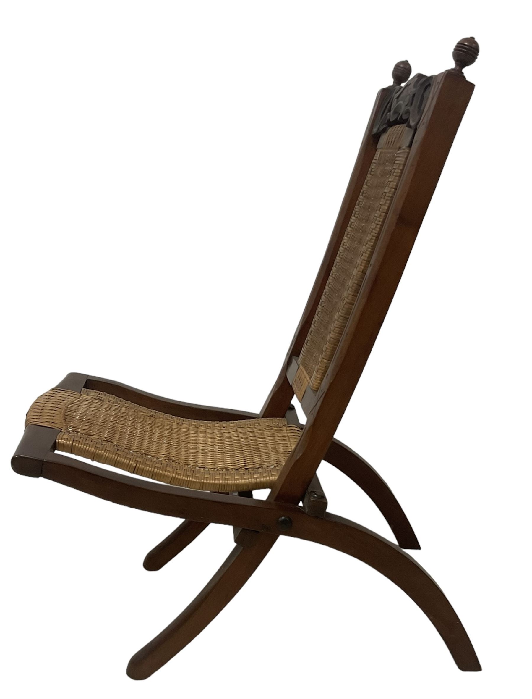 Victorian Aesthetic Movement mahogany framed folding campaign chair, pierced and carved cresting rail with carved and chamfered uprights, rattan back and seat