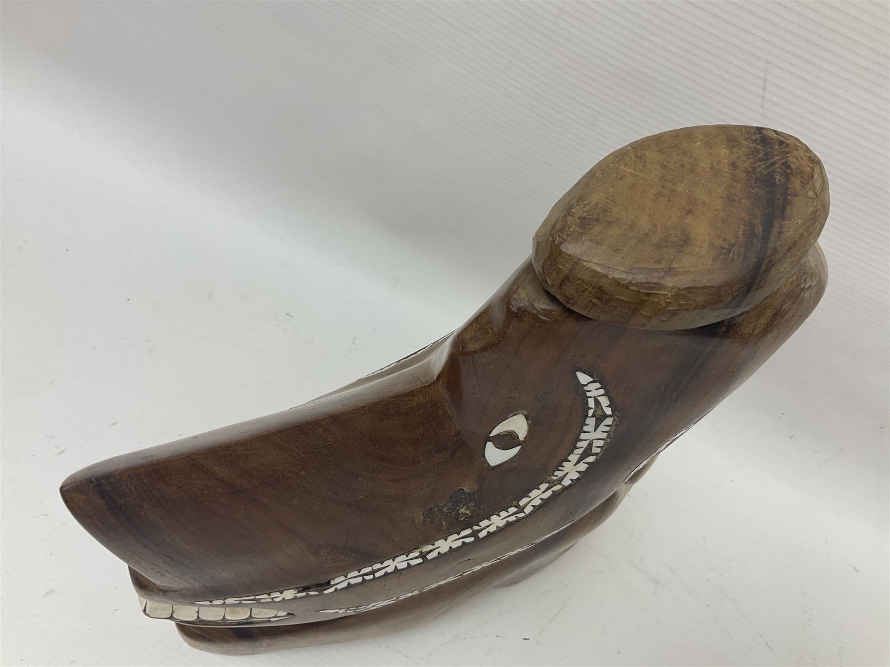 20th century Solomon Islands 'Nusu Nusu' canoe prow of typical carved form with mother of pearl inlaid detail, H29cm