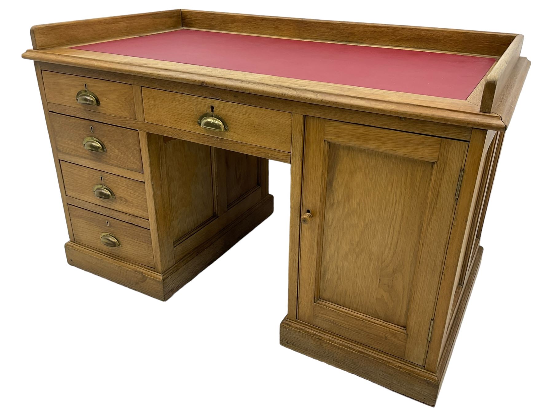 20th century oak desk, moulded rectangular top with raised back and inset leather writing surface, fitted with five drawers and single panelled cupboard, on moulded plinth base