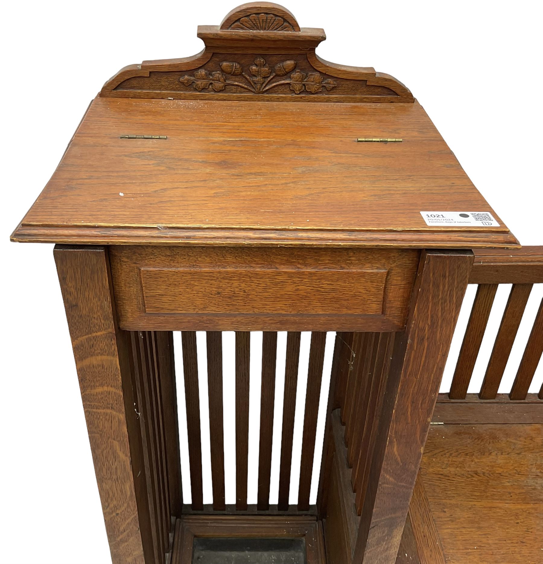 Victorian carved oak hall bench, raised shaped pediment carved with acorns and oak leaves, hinged lid over stick and umbrella stand with drip tray, fitted with a series of vertical rails, hinged and panelled box seat, carved with grotesque masks 