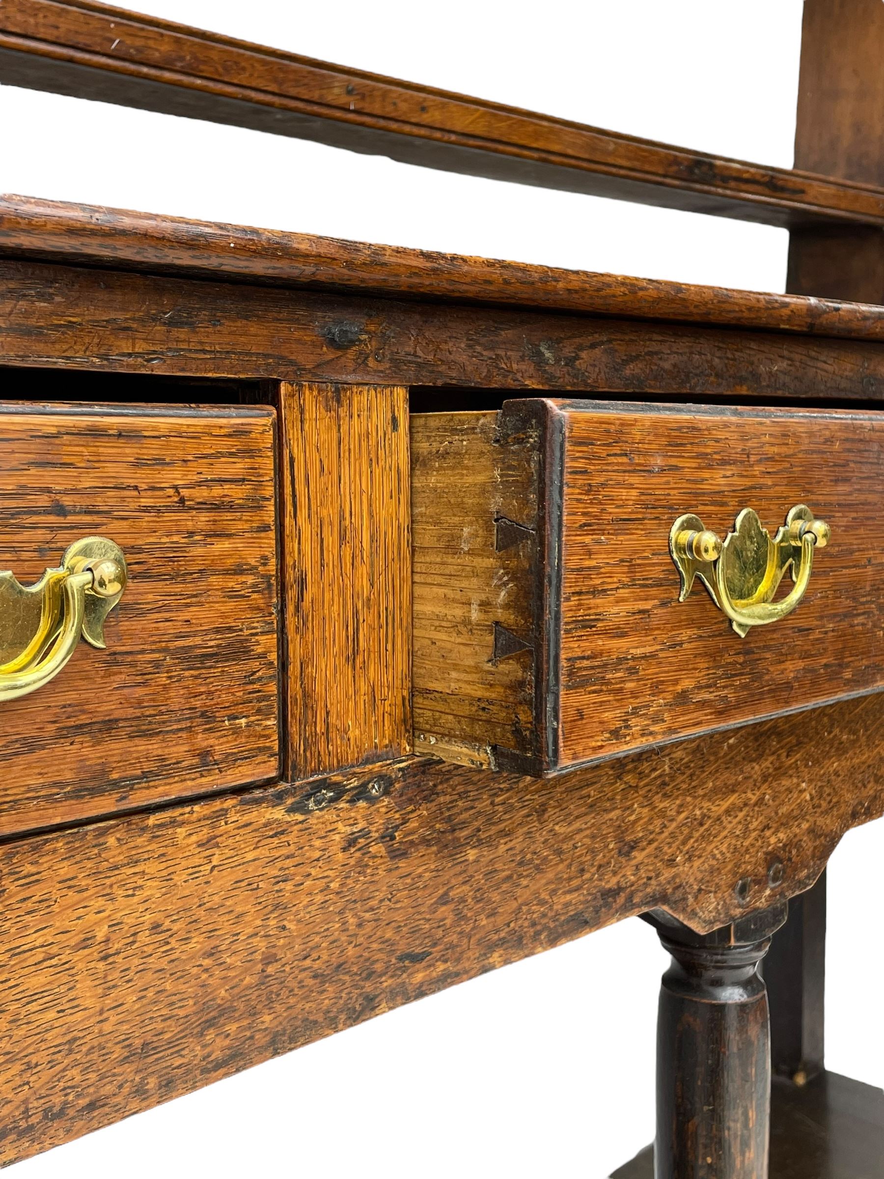 18th century oak dresser, raised three tier plate rack with moulded cresting rail, rectangular top over three drawers, the drawer fronts with moulded edges, turned supports united by pot board base 