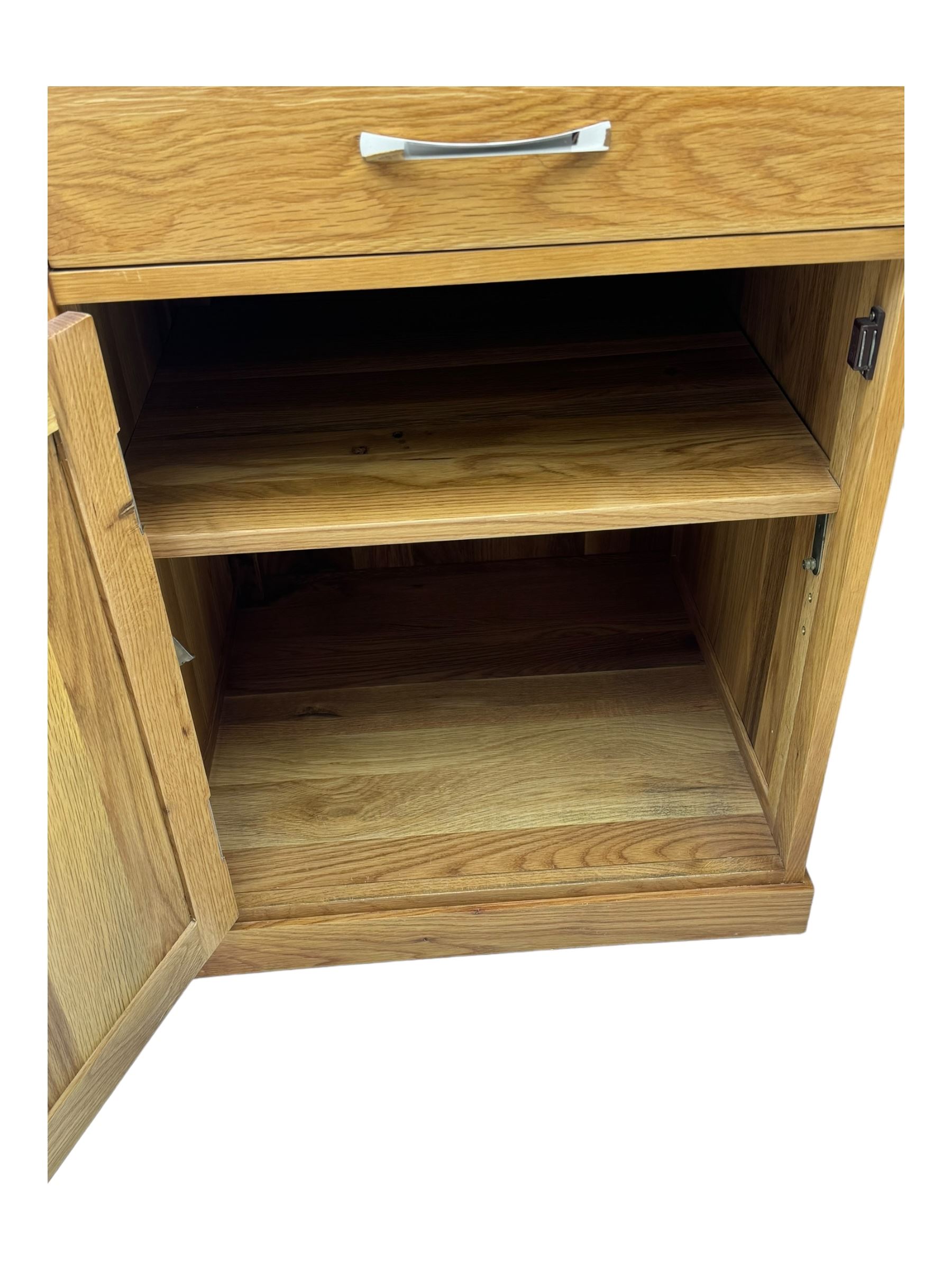 Contemporary light oak twin pedestal desk, fitted with three drawers over two cupboards with chrome handles, the central drawer with hinged front panel revealing pull-out keyboard tray, on plinth base