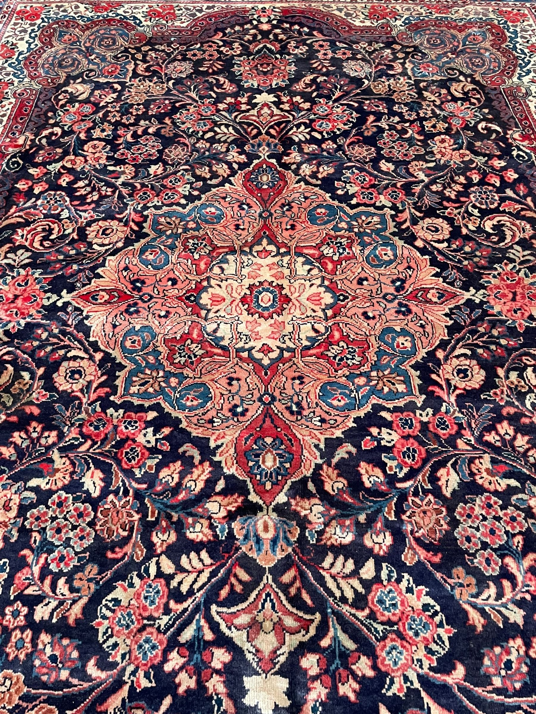 Persian Mahal indigo ground carpet, floral medallion on a field of swirling leafy branches and flower heads, shaped ivory field band decorated with flower head bouquets and trailing branches, the border decorated with floral motifs, within guard stripes