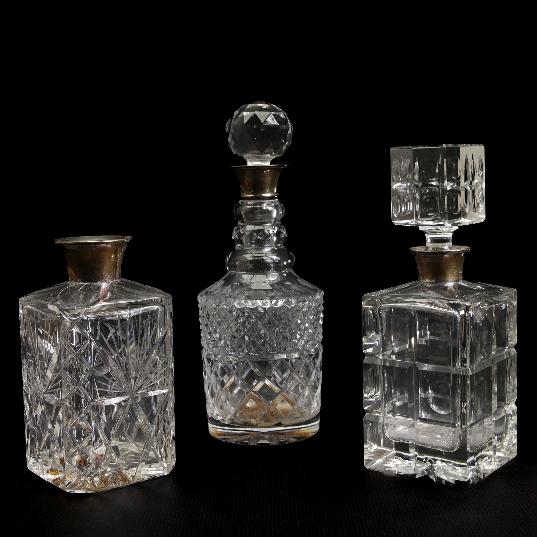 Square glass spirit decanter with silver collar and square stopper and two other decanters with silver collars (3)