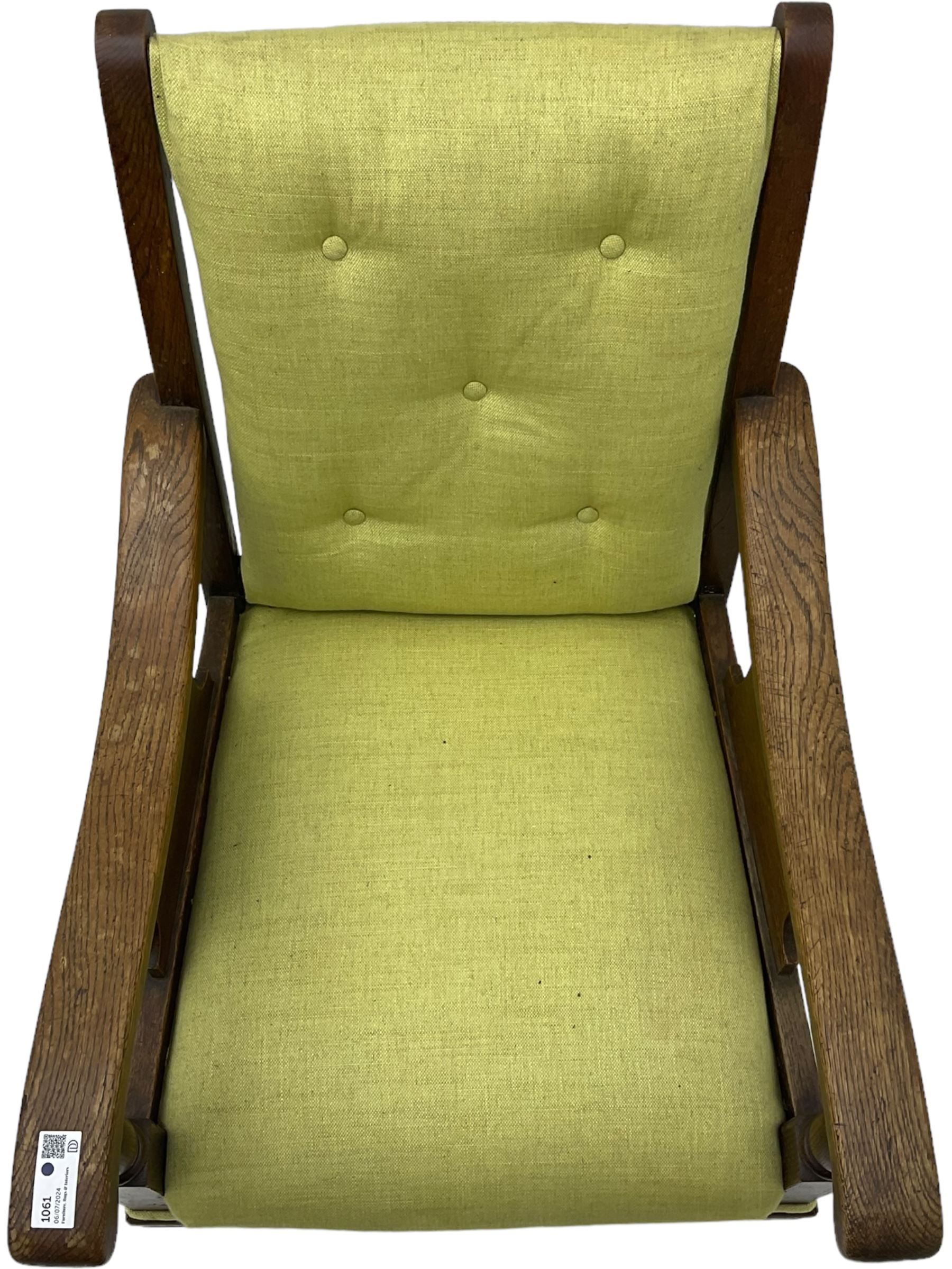 20th century oak framed rocking chair, curved armrests with shaped support panel, upholstered in lime-green fabric with button-tufting on the backrest, concealed springs to facilitate rocking motion underneath, supported by turned front legs with castors