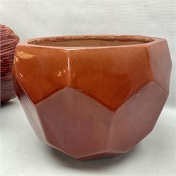 Two Bretby jardinieres, the first example with geometric hexagonal decoration in a red glaze, the second moulded as a flower head, in red glaze with yellow glaze to interior,  both with impressed marks beneath, tallest H25.5cm