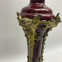 Late 19th century gilt metal mounted table lamp, the burgundy porcelain body of tapering form with applied gilt metal acanthus feet leading to cherub masks, overall including fixtures H59cm