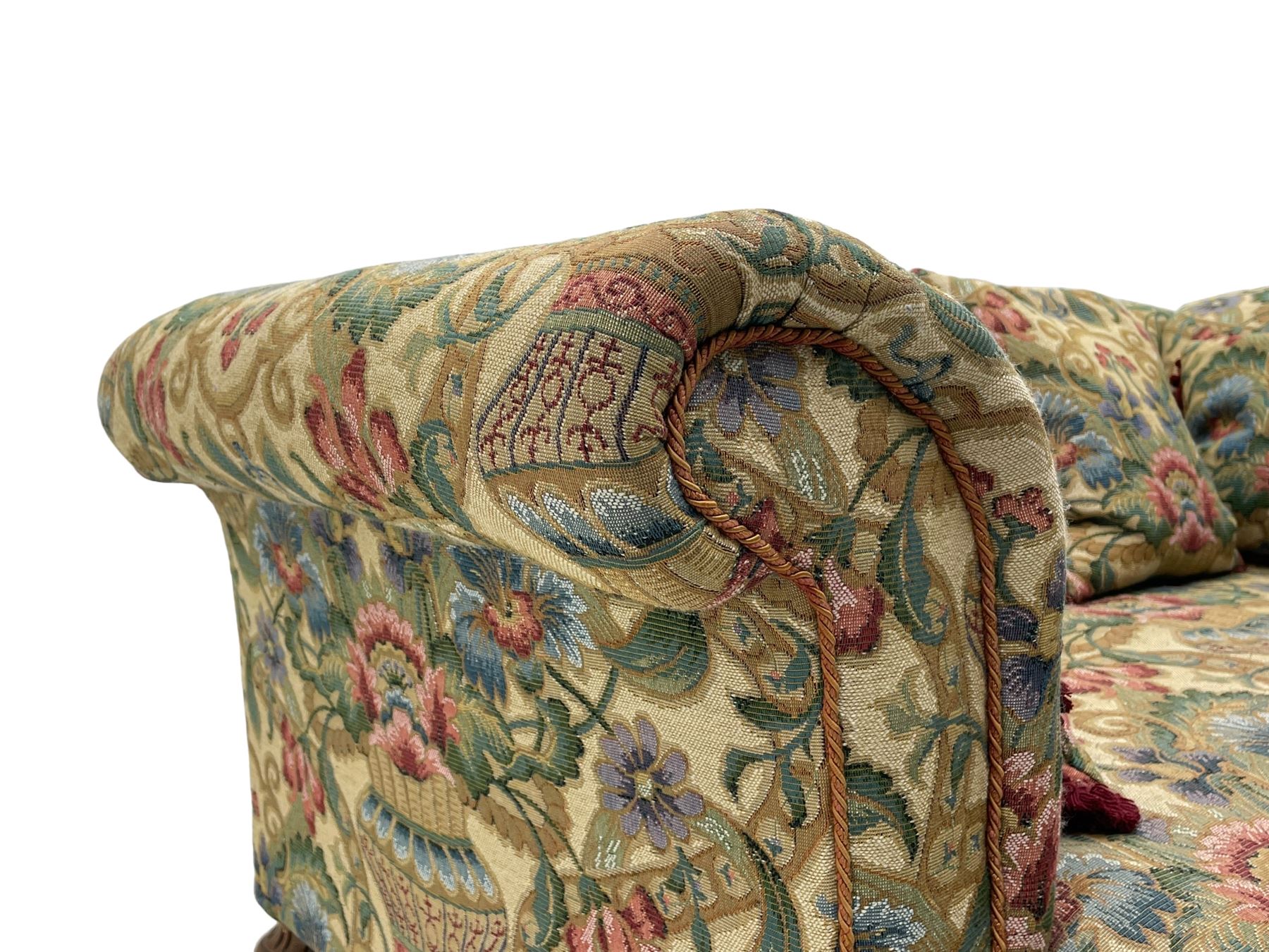 Mid-19th century walnut framed two-seat sofa, rolled arms over sprung seat, single drop-end action, raised on turned and fluted feet with brass cups and castors, upholstered by E & S Gott in traditional floral pattern fabric decorated with urns