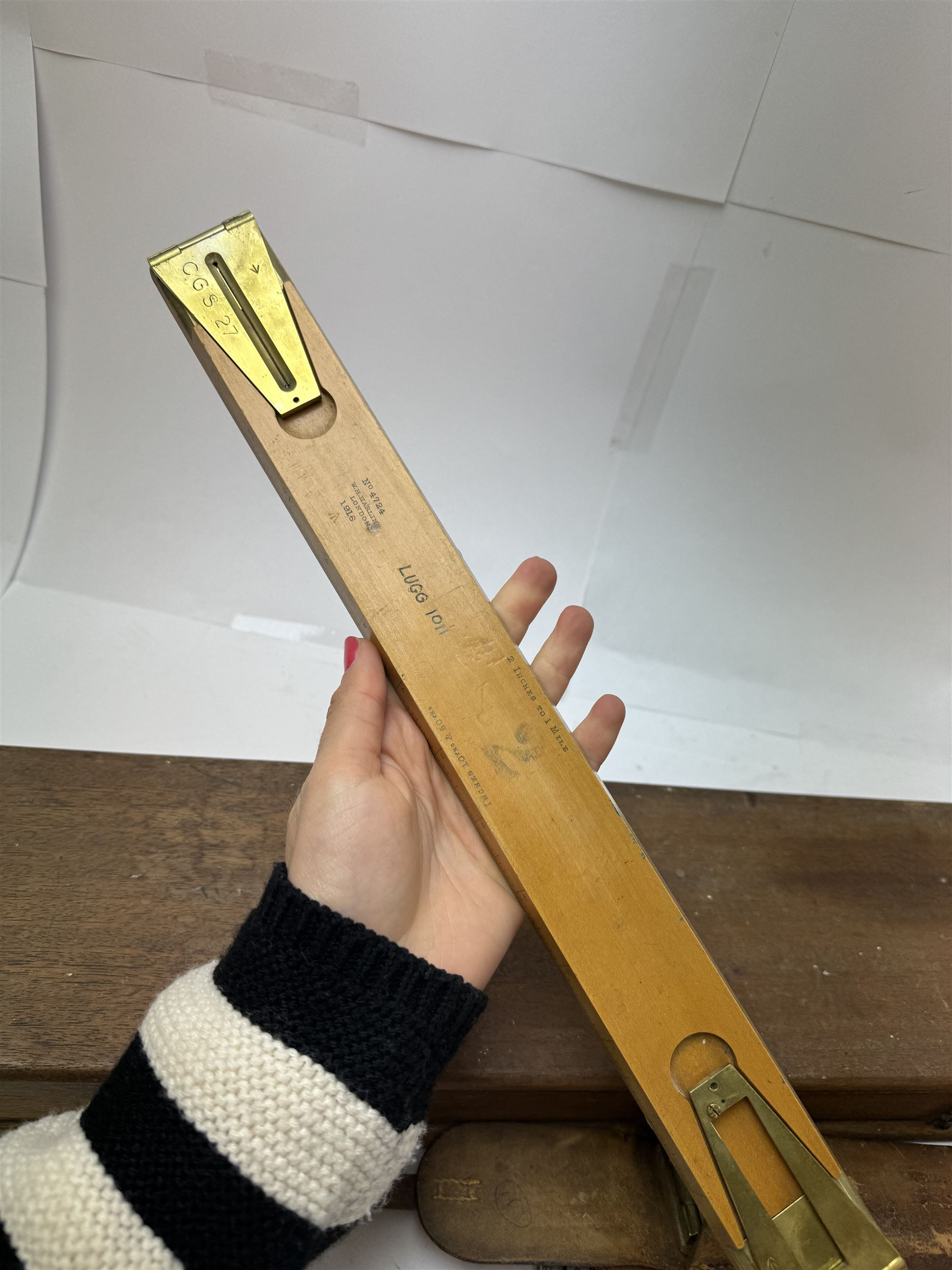 Early 20th century drawing instruments, to include a boxed set of large compasses, possibly for map drawing, marked 5, 6 and 7 miles, in fitted wooden case, together with two rules marked W. Harling and a parallel rule stamped R. E & Co MK II, all with broad arrow mark, contained within leather cases