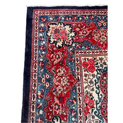 Persian Mahal indigo ground carpet, floral medallion on a field of swirling leafy branches and flower heads, shaped ivory field band decorated with flower head bouquets and trailing branches, the border decorated with floral motifs, within guard stripes