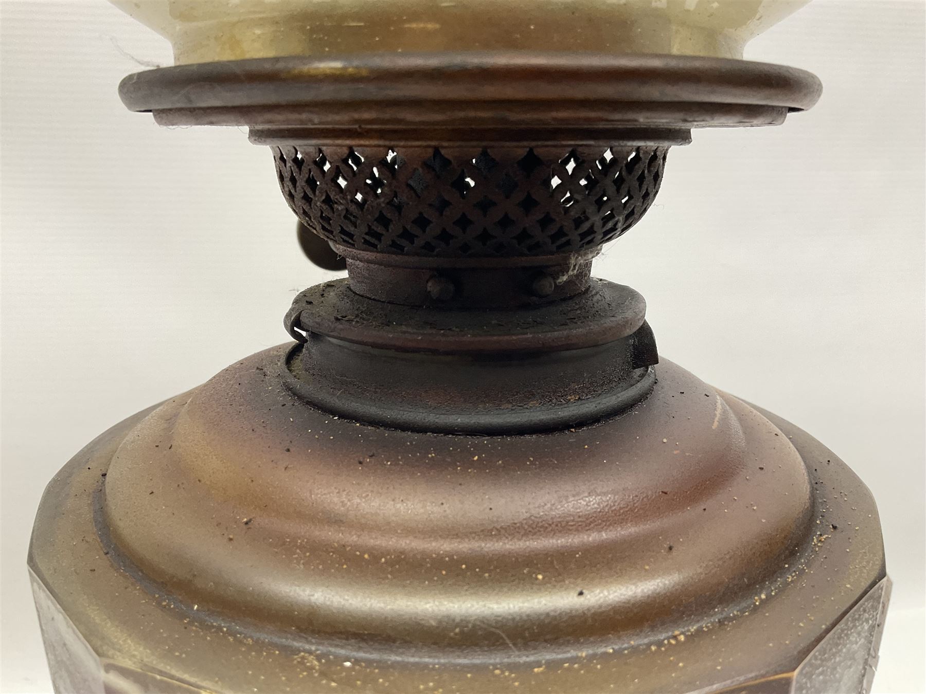 Victorian oil lamp, the faceted reservoir upon embossed copper stem and stepped circular ceramic base, with etched floral glass shade