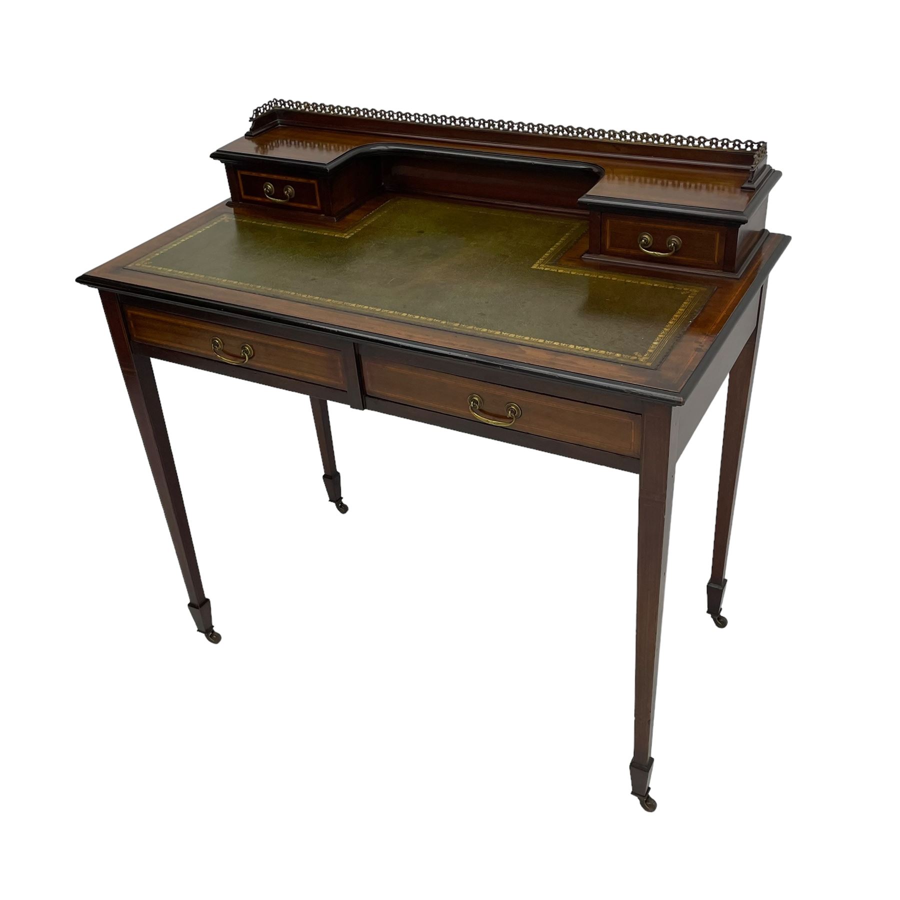 Edwardian inlaid mahogany writing desk, raised back with gilt metal gallery over two small drawers with satinwood banding, the rectangular moulded top with green leather inset writing surface, fitted with two drawers, on square tapering supports with spade feet, brass and ceramic castors 