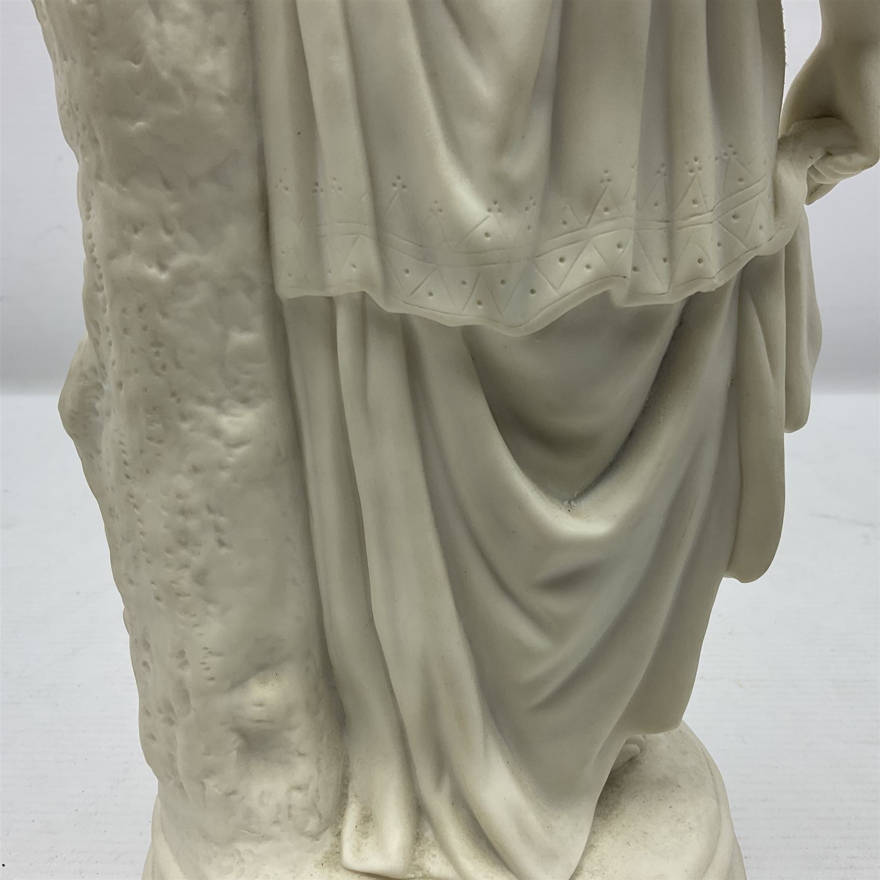 Parian figure modelled as a female in classical dress leaning upon a tree stump, H36cm