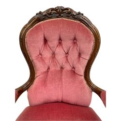 Victorian carved walnut open armchair, foliate carved cresting rail over butted back and sprung seat, upholstered in pink velvet scrolled arm terminals with moulded scrolling vines terminating to cabriole supports and ceramic castors