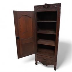 19th century French walnut hall cupboard, the frieze carved with a bouquet of flowers and trailing foliate decoration, enclosed by single panelled door over single drawer, the curved outer corners decorated with trailing leafy branches and flower heads, shaped apron with scroll carved cabriole feet 