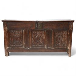 18th century carved oak coffer or chest, sloped hinged lid over panelled front, carved with three Northern European portraits with foliage surrounds decorated with birds, fitted with wrought metal carrying handles, on fluted stile supports 