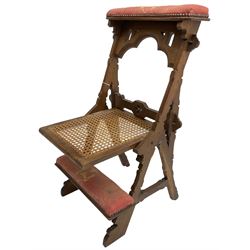 Late Victorian oak metamorphic prie-dieu chair, ecclesiastical design with pegged construction, upholstered kneel rest and top rest, hinged cane work seat