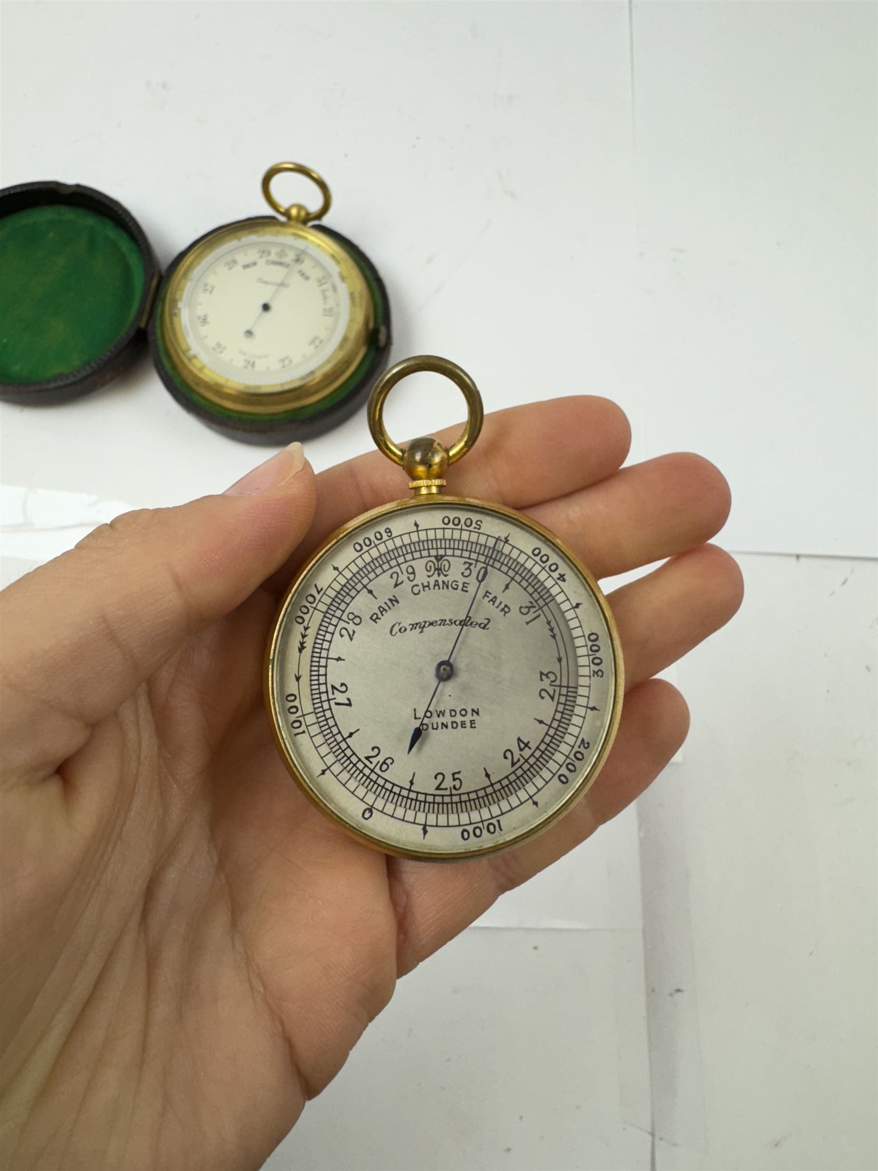 Lowdon Dundee, an early 20th century leather cased pocket barometer with silver dial, D4cm, together with another larger and later example, both cased